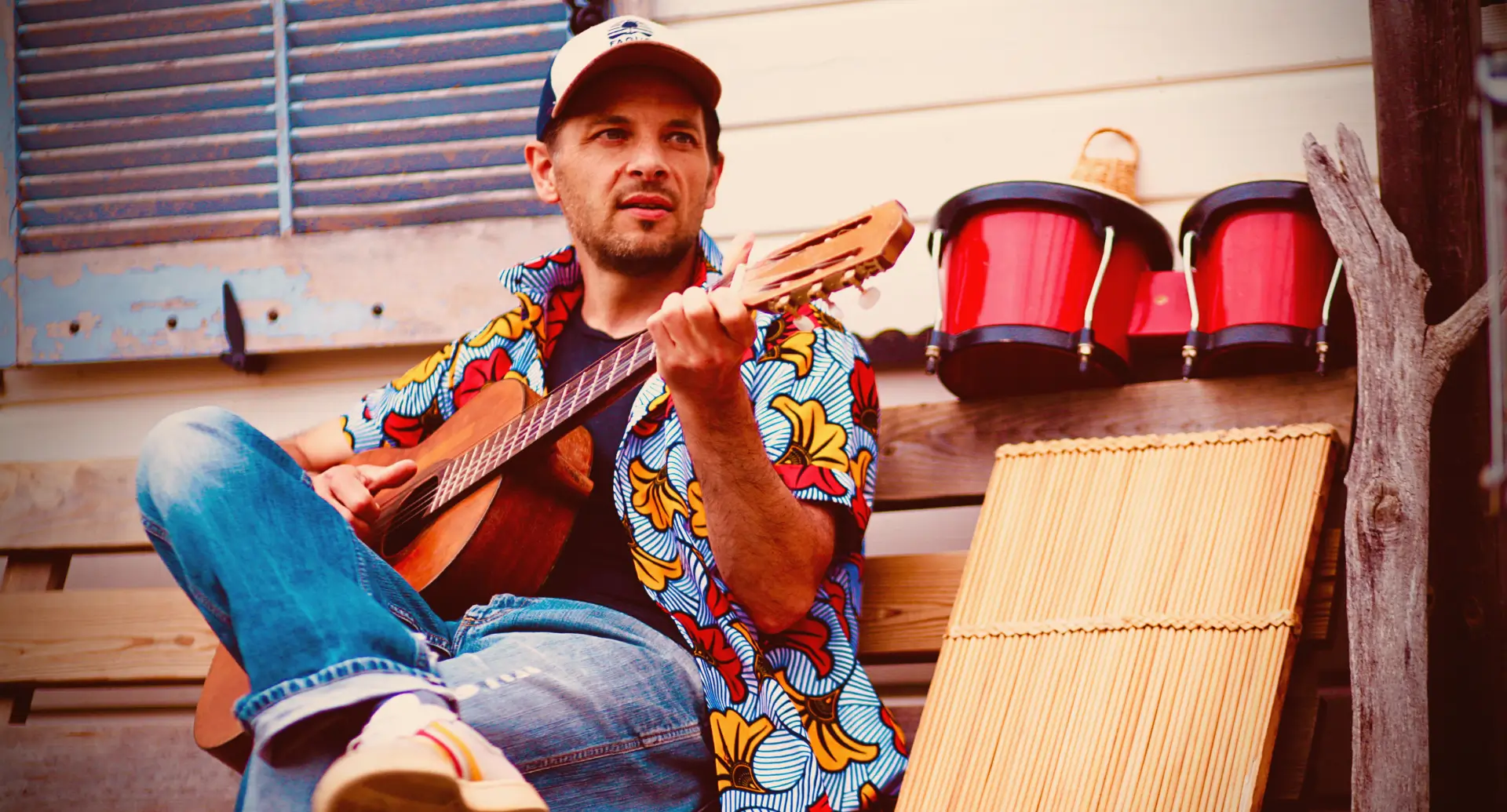 Artiste assis sur un banc avec une guitare à la main